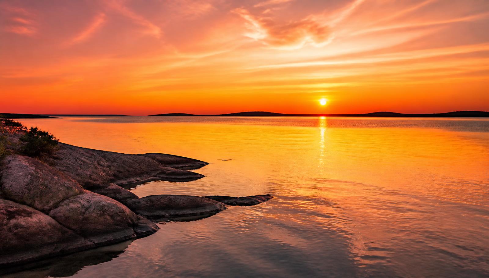 Sunset over Georgian Bay with amber and rose sky reflected on the water